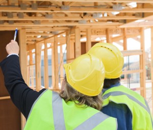 house frame work being inspected by construction workers