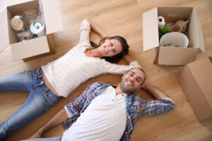 a couple lying in their living room packing for a move