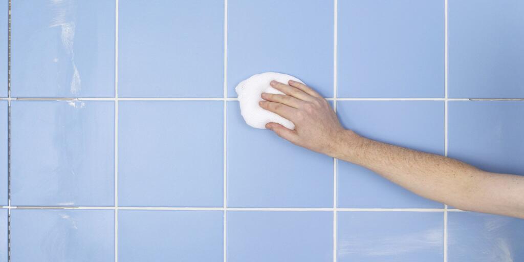 Person scrubbing dirty grout tile