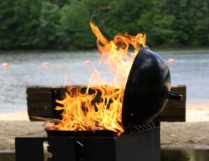 flaming grill on a lakeside beach 