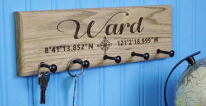 lake-inspired wooden key holder on wall with GPS coordinates and family name