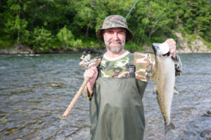 man with fish trophy in boat