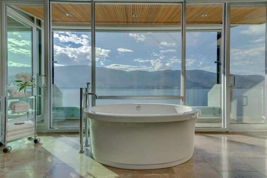 Wide bathtub with view of mountains and lake