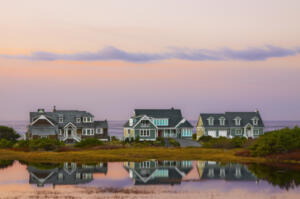 three lakefront houses at sunset