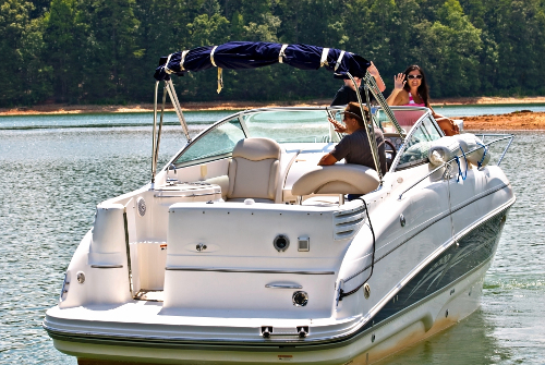 Woman waving from deck boat. Boat description found in "Buying the Best Boat for You."