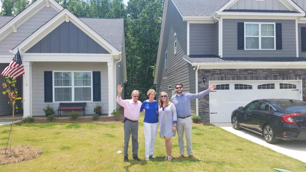 Lake Homes Realty clients, The Morrisons with daughter and son-in-law, in front of new homes.