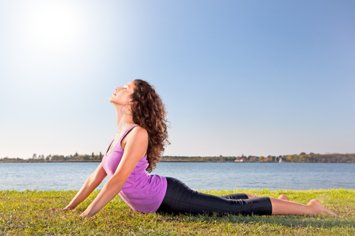 Woman in cobra yoga pose, healthy living at the lake