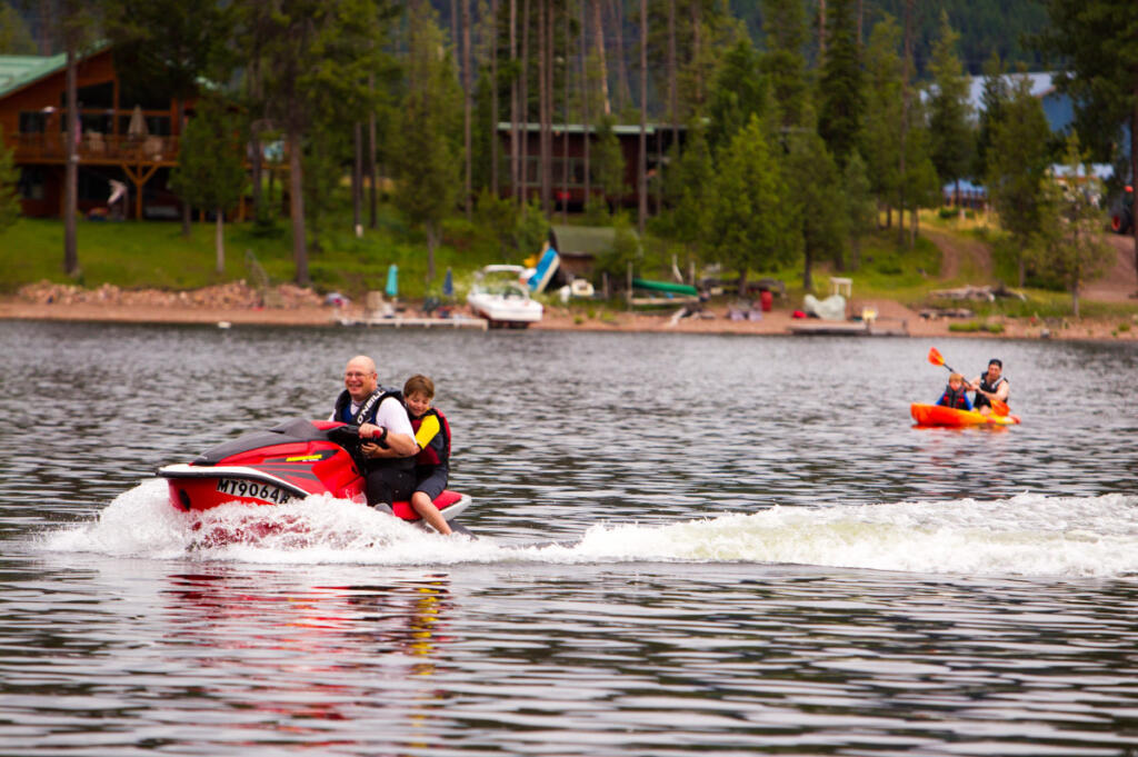 Family members jet skiing and kayaking on lake 
