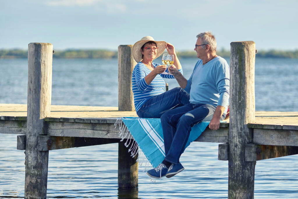 アメリカでも有数のリタイアメントレイクのドックで、リタイアしたカップルが乾杯しています。's best retirement lakes