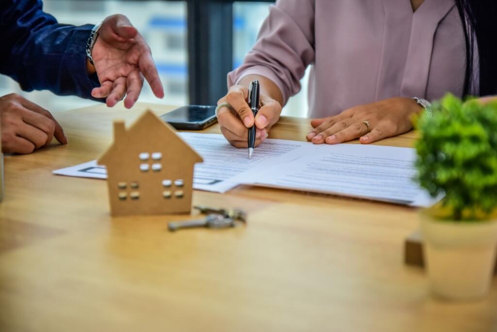 Person signing homeowner association contract the hidden costs of buying a lake home