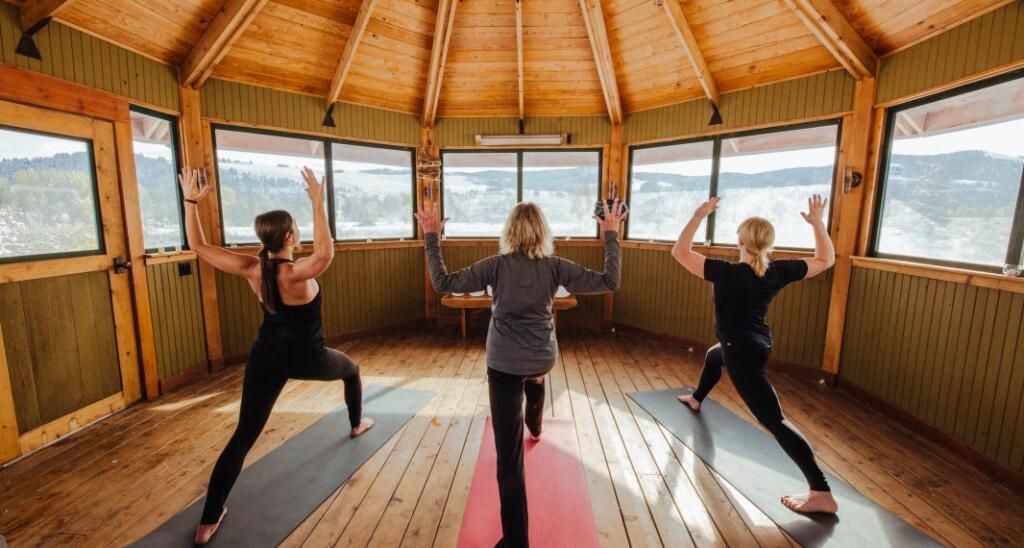 3 women doing yoga lake fitness active exercise at the lake