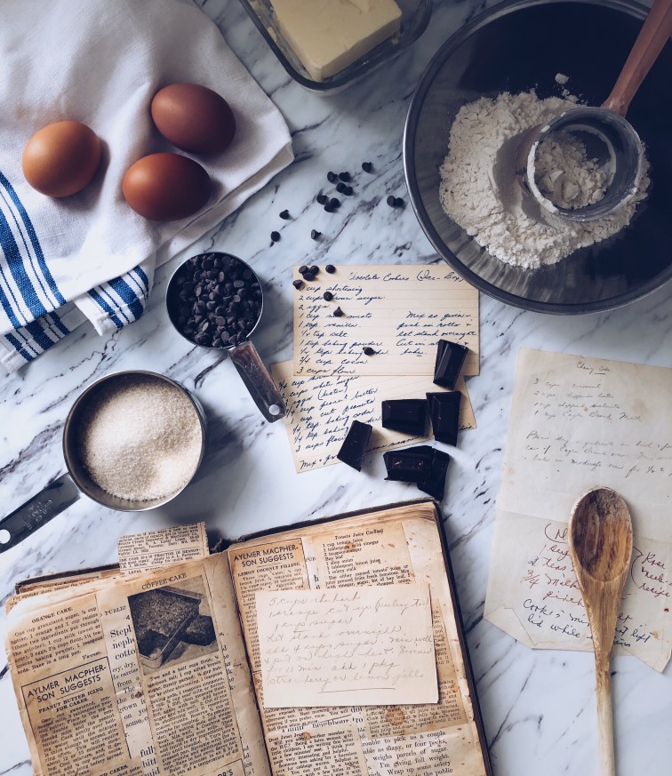 Recipe book and ingredients laid out on marble counter top