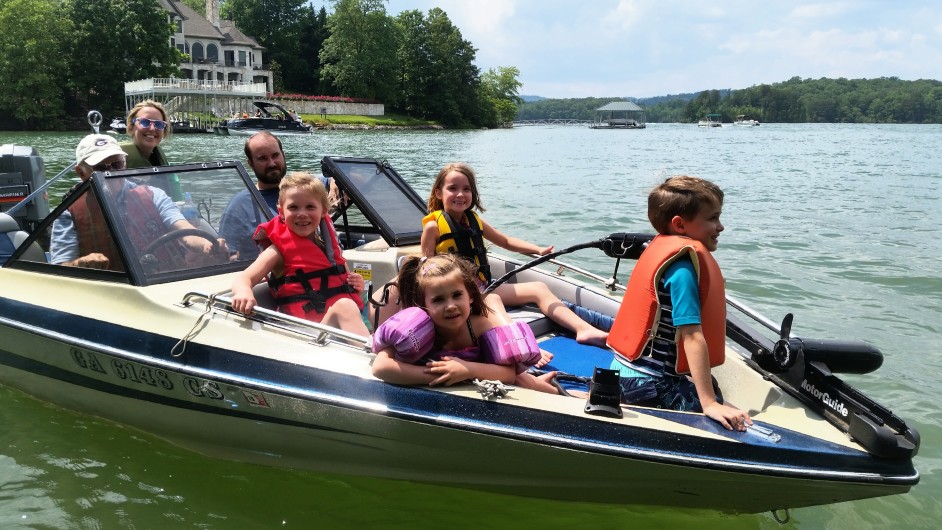 Family and children boating on lake during summer
