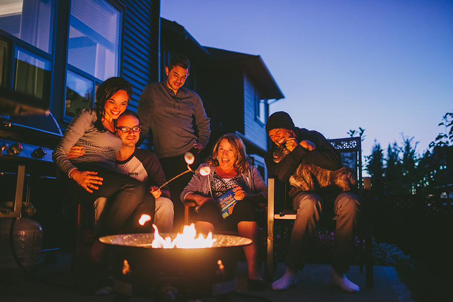 Family sitting around fire pit roasting marshmellows