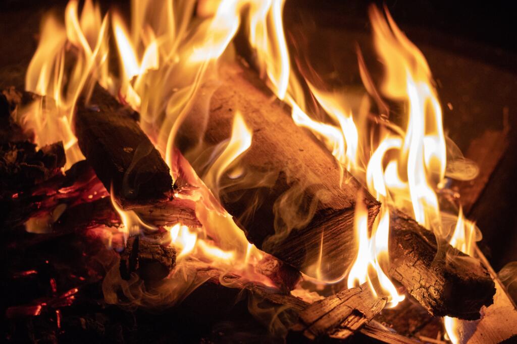 Lit firewood in fireplace