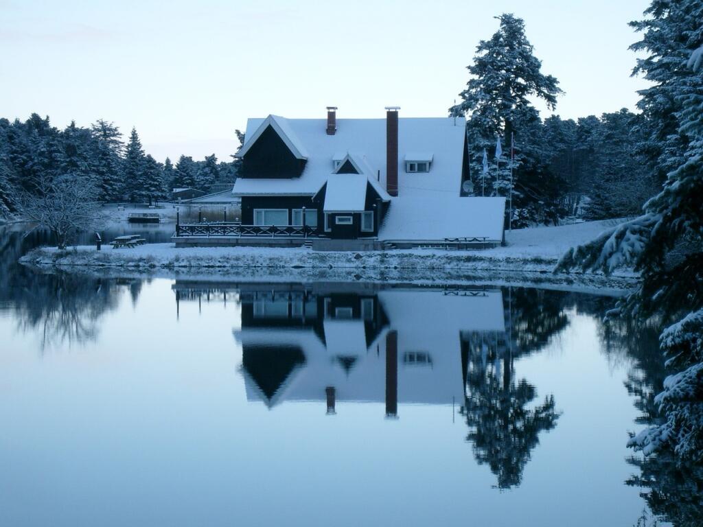 Lake house during winter with snow and still lake