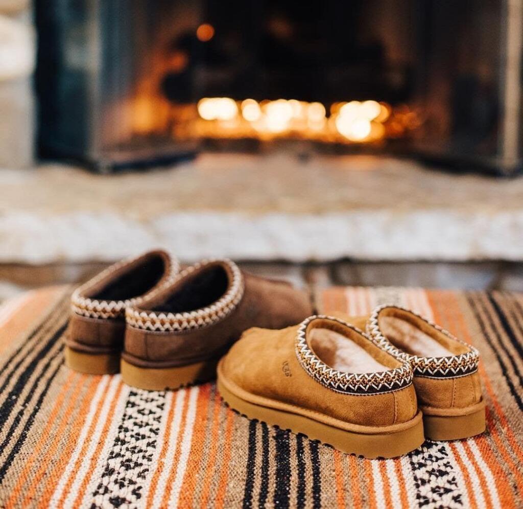 Cozy winter Ugg slippers in front of fireplace at lake house