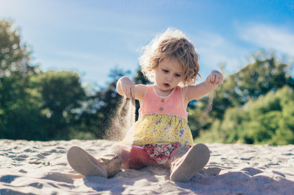 Little girl playing in sand at beach