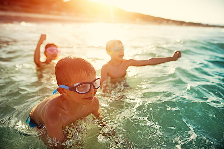 Happy children playing in water at beach