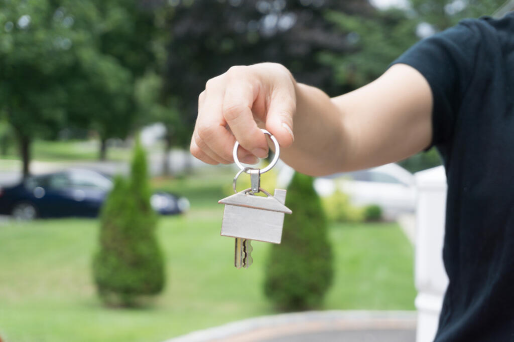 Person handing house keys to renters