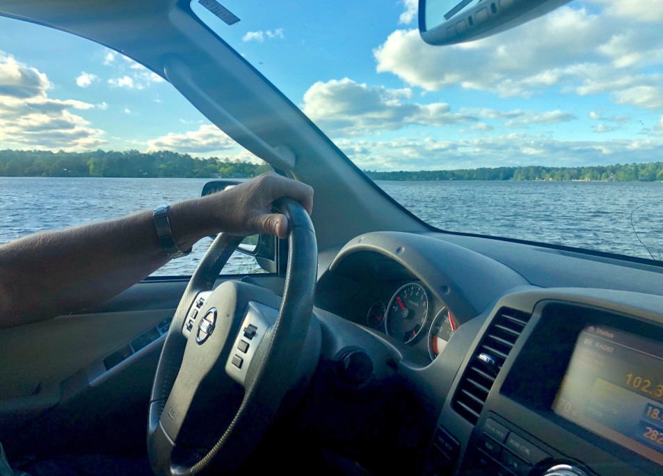 Person driving alongside lake living on the water