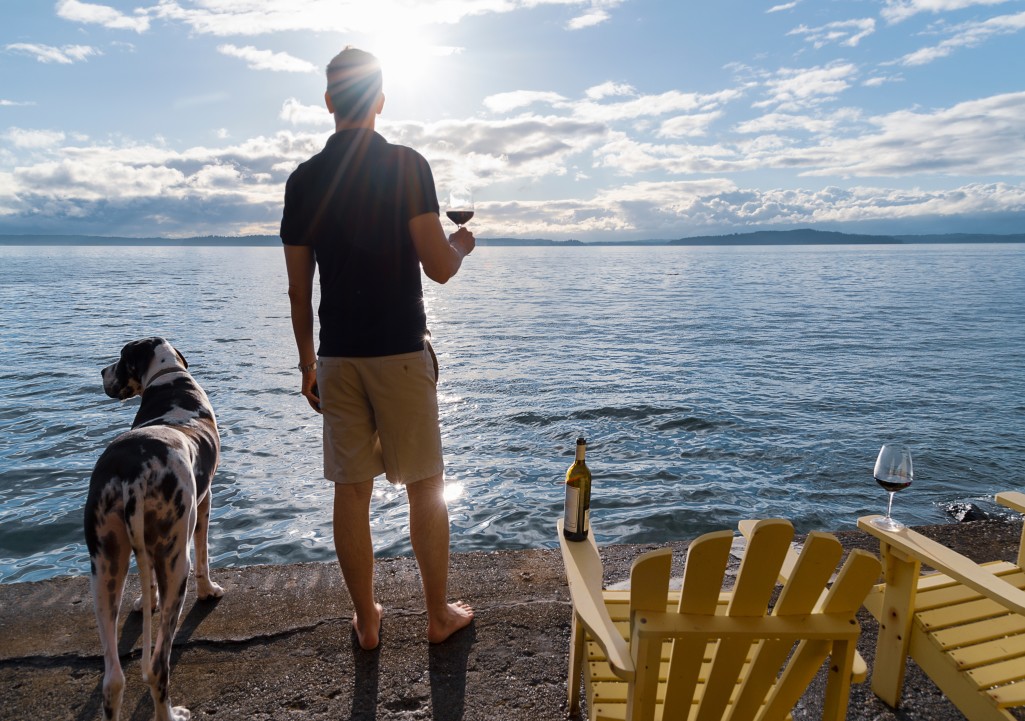 man holding glass on wine next to door on lake beach - lake front access