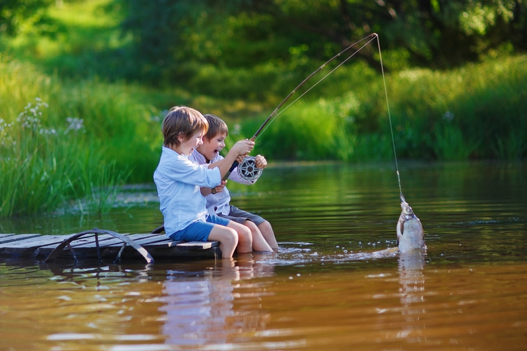 two little boys fishing in lake