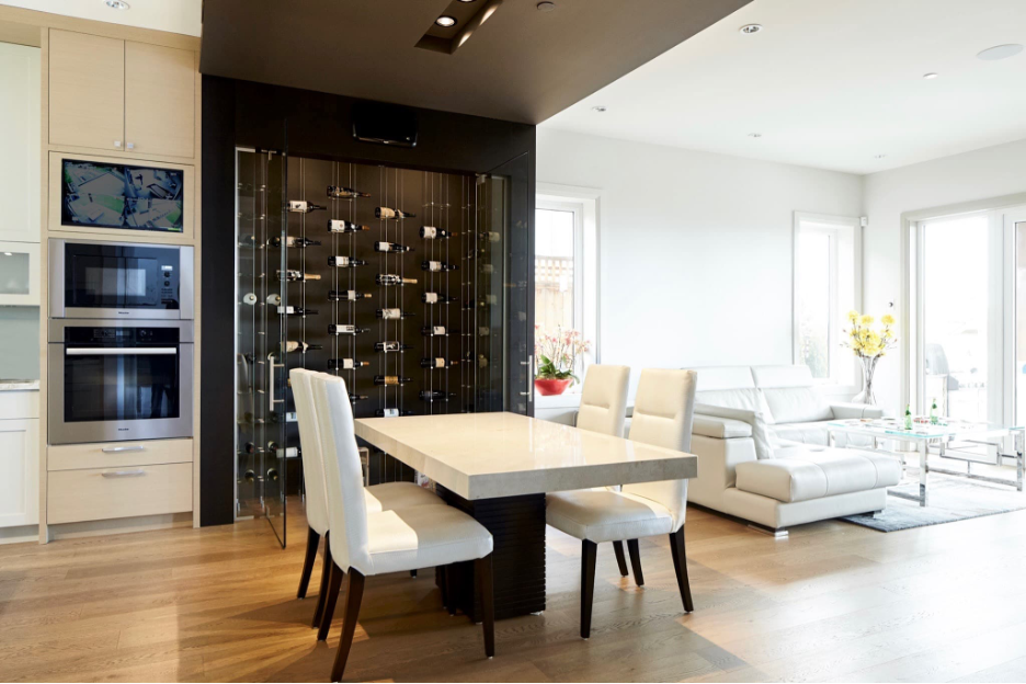 modern wine wall unit with floating cable racks and through-the-wall cooling system, adjacent white marble dining table with white lather chairs, built-in appliances, adjacent all-white living area with white leather sectional