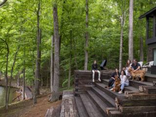 Billy Reid and family with dog on steps in front of Wilson Lake, Alabama