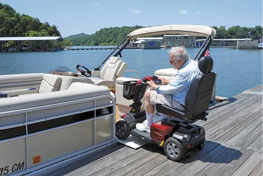 man on scooter wheelchair getting from the dock onto a pontoon with widened entrance