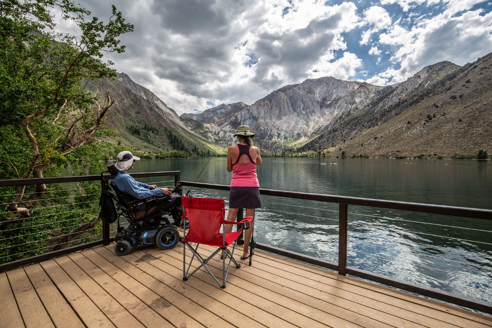 pier with lowered railings for effortless fishing for those with disabilities, couple gazing out at the lake and mountains