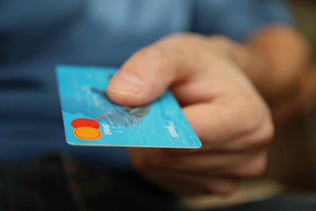 person holding a blue debit card