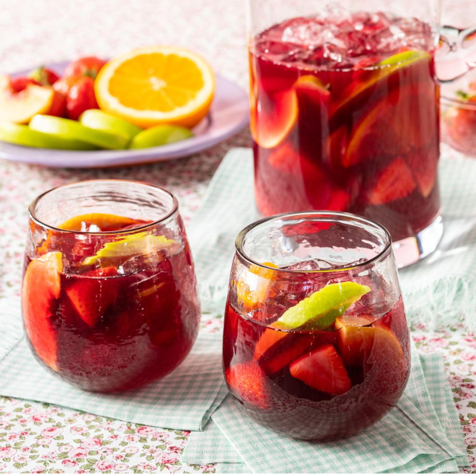 Red Sangria served iced glasses with apple slices, strawberries, and orange slices.