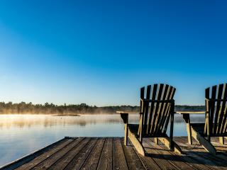 Adirondack chairs on pier looking out to the lake