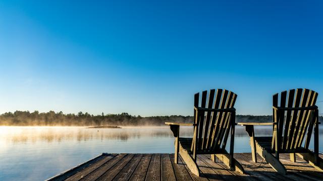 Adirondack chairs on pier looking out to the lake