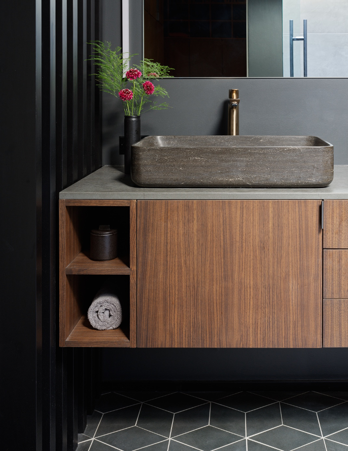 Primary bathroom sink, cabinetry, and black slatted wood privacy screen in Alden Mason Home, Seattle, WA