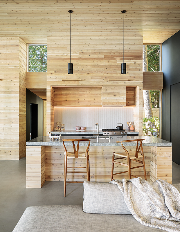 Sleek light cedar-clad kitchen with granite-topped island that mimics the hues of the landscape