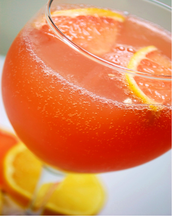 Sparkling Citrus Champagne Punch in a wine goblet with ice and slices of grapefruit on top.